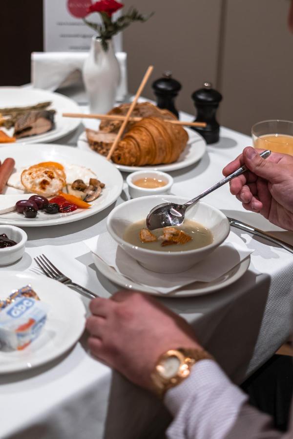 Hotel Manami Pristina Esterno foto A person using a soup spoon