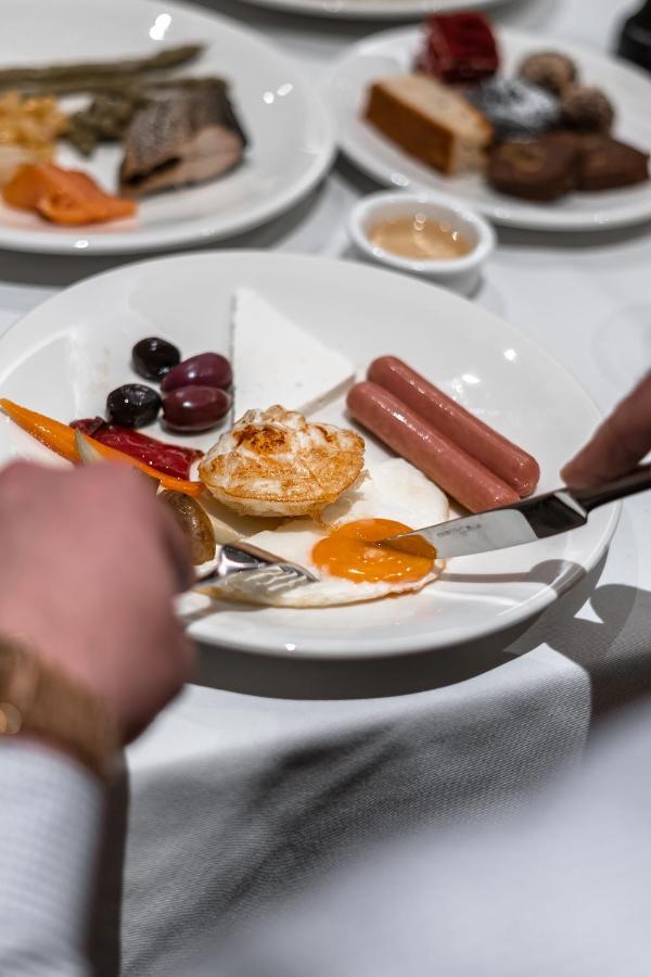 Hotel Manami Pristina Esterno foto A cooked egg being cut with a knife